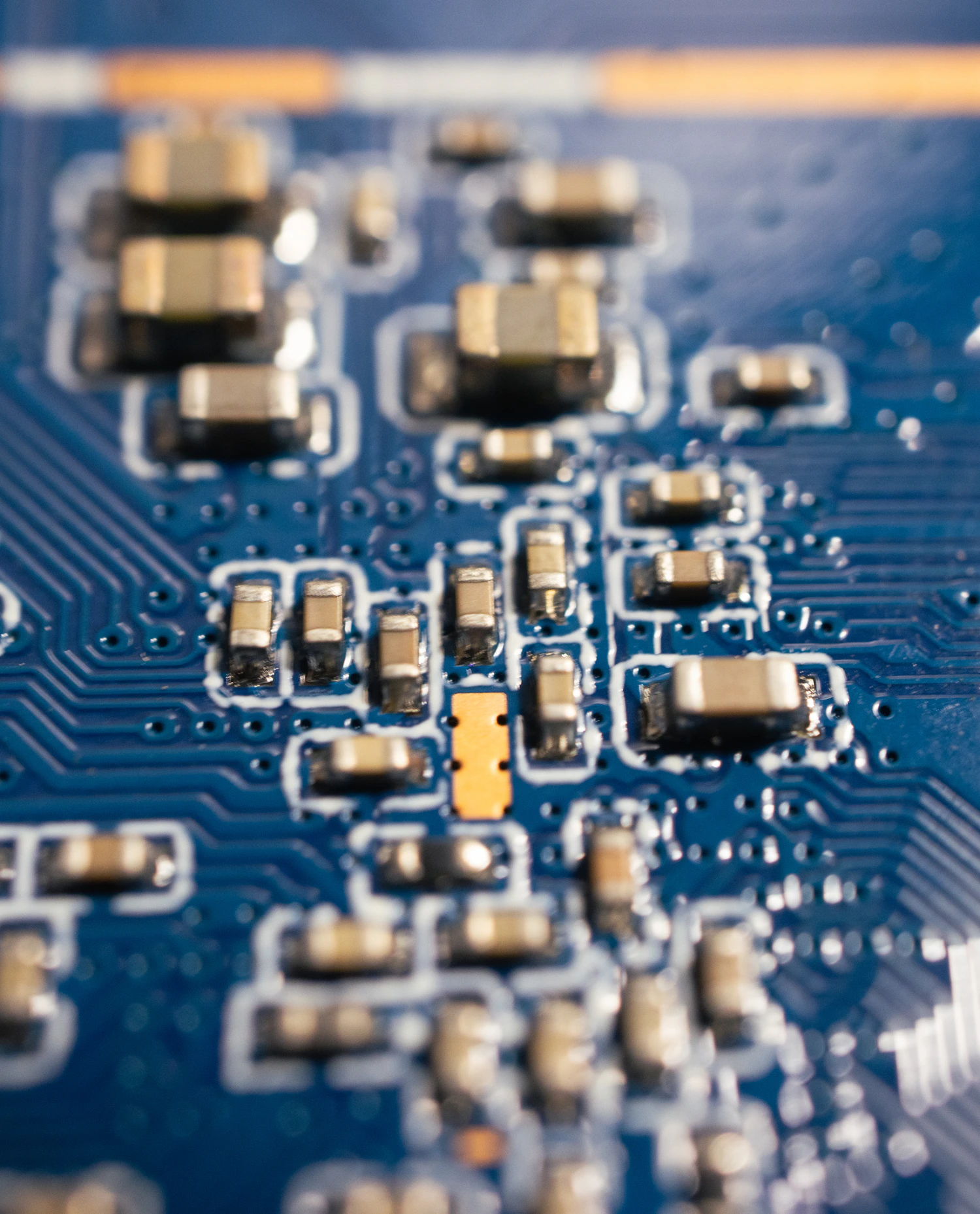 Macro photograph of components and traces on a blue printed circuit board