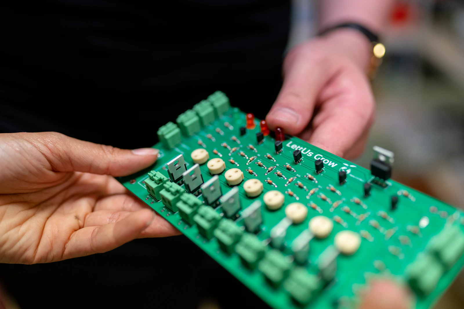 Stock photograph of hands holding an assembled electronic circuit board