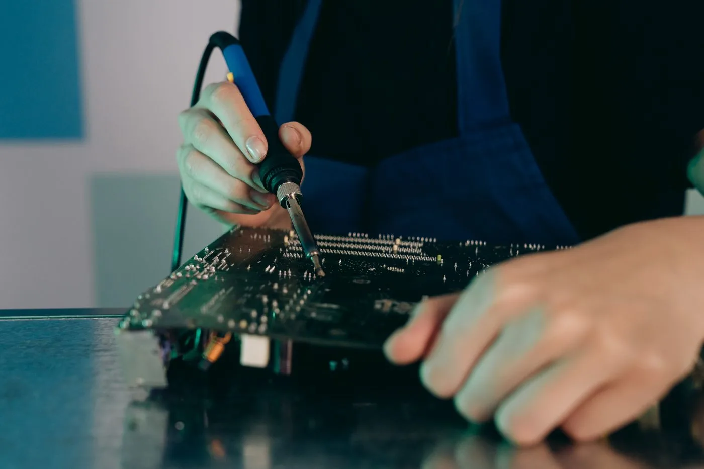 Illustrative stock photograph of hands working on an electronic circuit board